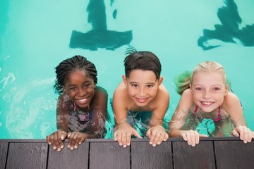 Cute swimming class in pool with coach