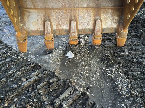 Z&auml;hne von Schaufelbagger graben sich in die Erde