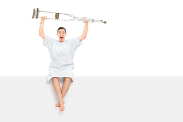 Overjoyed patient raising his crutches in the air