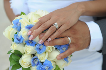 Wedding couple hands on flowers