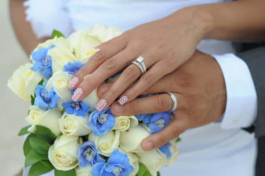 Wedding couple hands on flowers