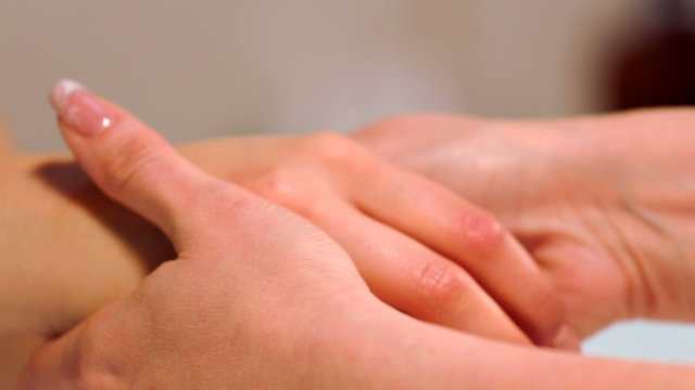 Massage the fingers and wrist in a spa salon.