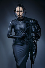 Fototapeta na wymiar Beautiful woman in black Gothic dress. The face wearing a mask.