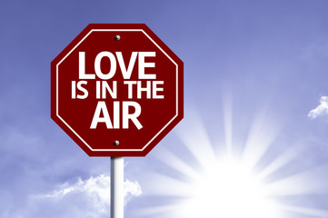 Love Is In The Air written on red road sign