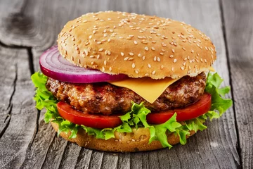Poster hamburger met gegrild vlees en kaas op een houten ondergrond © koss13
