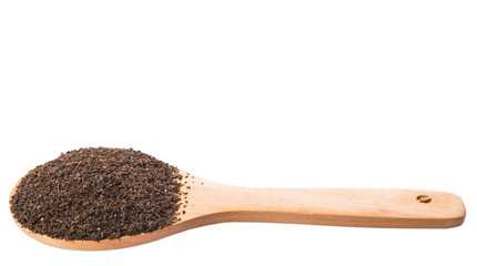 Dried, processed tea leaves in wooden spoon over white 