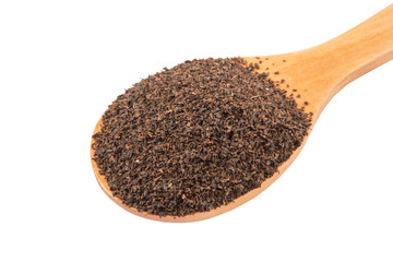 Dried, processed tea leaves in wooden spoon over white 