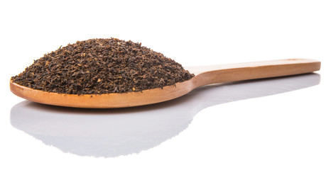 Dried, processed tea leaves in wooden spoon over white 