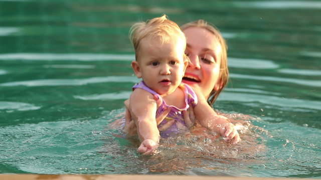 mother and douther swim in the pool