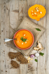 Pumpkin soup in bowl on wooden background
