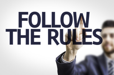Business man pointing the text: Follow the Rules