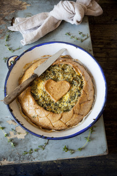 spinach and chicory savory pie on vintage plate on rustic table