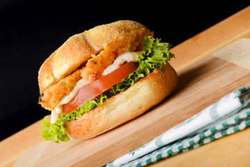 Appetizing fish burger on wooden board