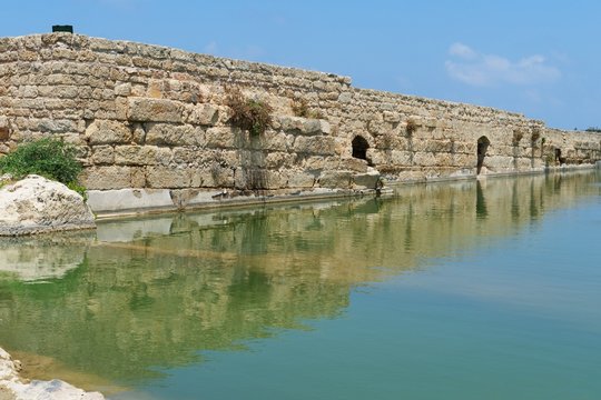 Ancient wall reflecting in the pond in Nahal Taninim, Israel