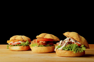 Appetizing veggie, fish and beef burgers with toppings