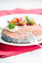 Grilled Salmon with Fresh vegetables on red background