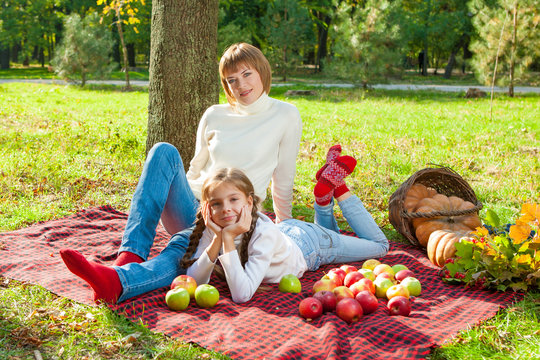 Happy mother with little daughter in autumn park