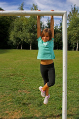 BAMBINA APPESA SULLA POSRTA DI CALCIO