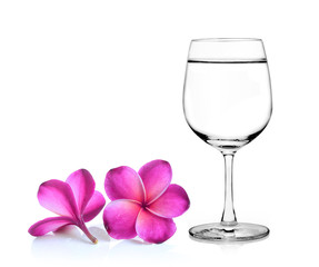 Glass of water and frangipani flower isolated white background