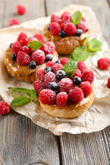 Sweet cakes with berries on table close-up