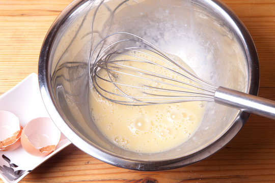 Whisk And Beaten Eggs In A Bowl