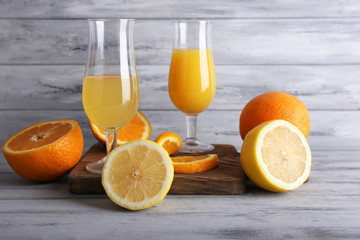glasses of juice with fresh fruits on grey wooden table