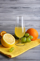 glass of juice with fresh fruits on grey wooden table