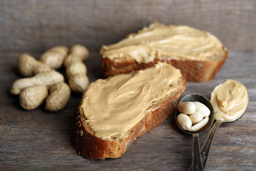 Tasty sandwiches with fresh peanut butter on wooden background