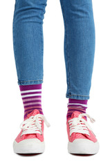 Female legs in colorful socks and sneakers isolated on white