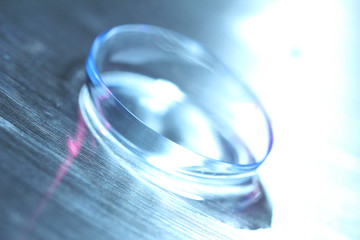 Contact lens with water drops on bright background
