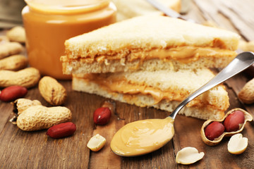 Bread slices with creamy peanut butter on wooden table