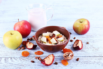 Bowl of oatmeal, walnuts, dried apricots, apples and yogurt