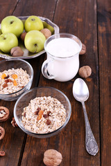 Oatmeal in bowls, yogurt, apples, dried apricots and walnuts