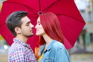 Loving couple under an umbrella in autumn park
