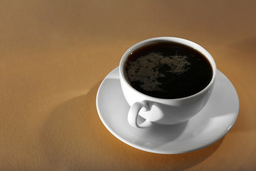 Cup of coffee on beige background