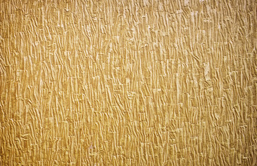 Gold background texture. Wallpaper on the wall.