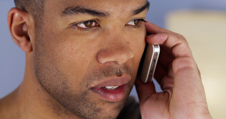 African man listening on smartphone