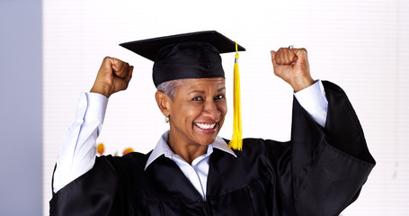 Enthusiastic mature black woman in graduation gown