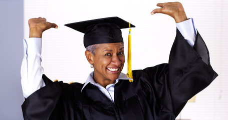 Enthusiastic mature black woman in graduation gown