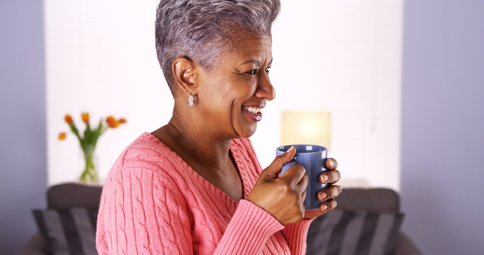 Mature African woman smiling with coffee mug