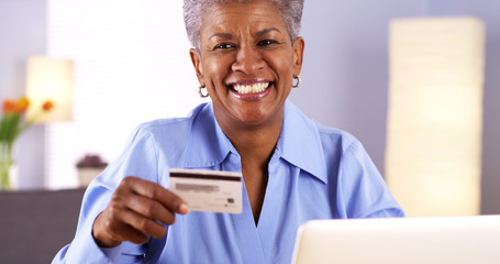 Happy Mature Black woman holding credit card