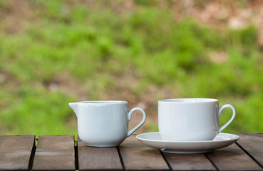coffee cup on wood over nature background