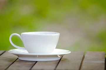 coffee cup on wood over nature background