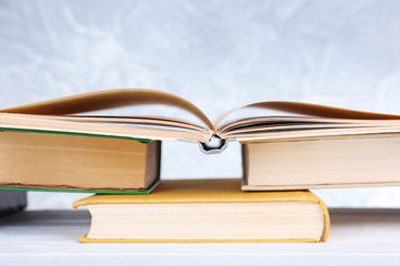 Books on wooden table on light background