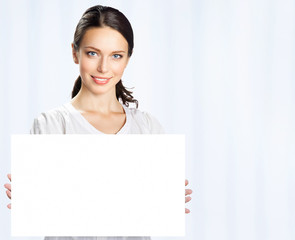 Businesswoman showing blank signboard, at office