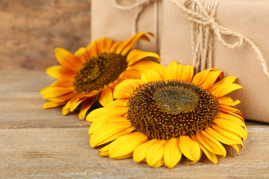 Sunflowers with present boxes on wooden background