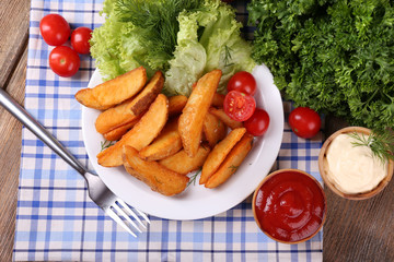 Homemade fried potato on plate on wooden background