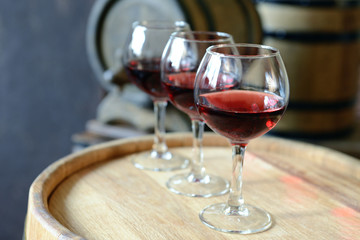 Glasses of wine in cellar with old barrels