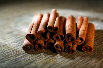 Cinnamon on dark wooden background, close-up