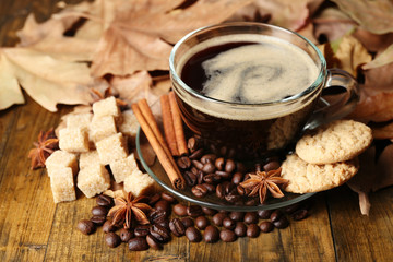 Glass cup of coffee, tasty cookies and autumn leaves